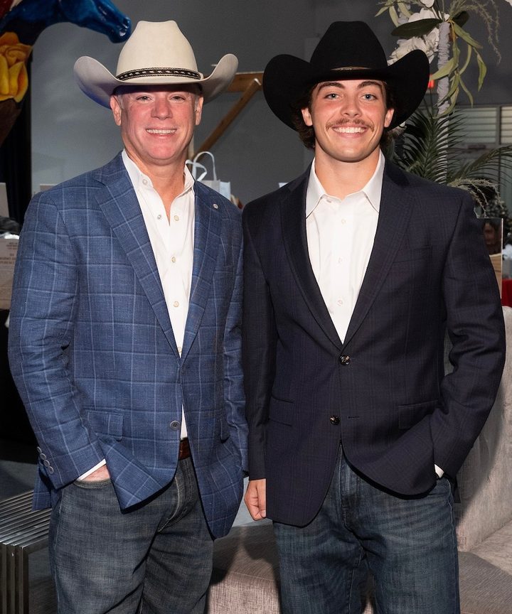 Alex Ackel in a black cowboy hat with a fellow auctioneer at a charity event